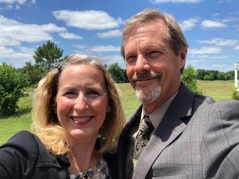 female client with her husband smiling for the camera