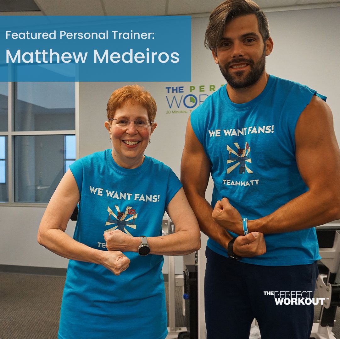 Trainer Matt Medeiros standing next to a TPW member while they flex their biceps