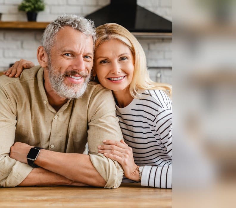 Healthy and happy couple embracing in their home, embodying the vitality achieved through The Perfect Workout's program.