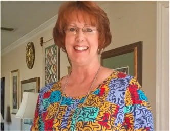 Smiling woman in a colorful blouse, a satisfied participant of The Perfect Workout program.