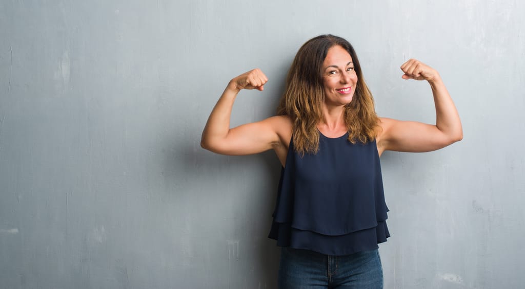 a female smiling and flexing her arm muscles