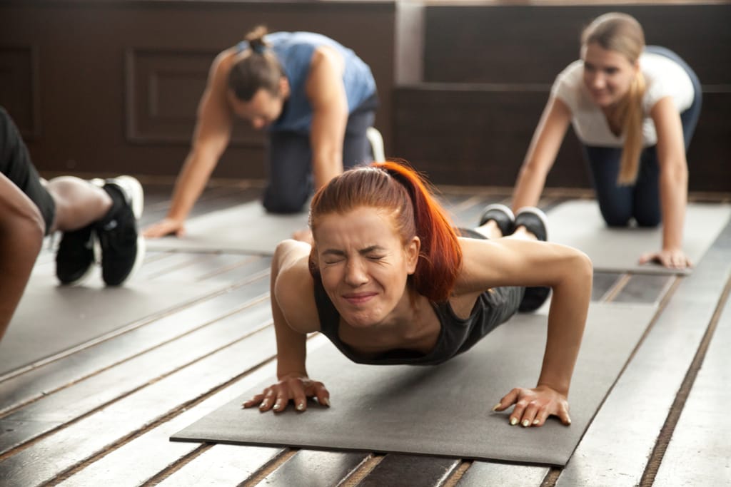 a female struggling to do a pushup