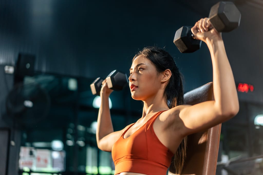Woman strength training with dumbbells