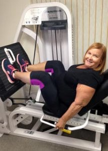 woman doing leg press while personal training