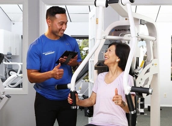 female client with male personal trainer in studio