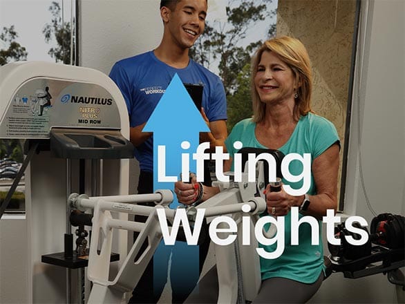 woman over 60 lifting weights with a personal trainer