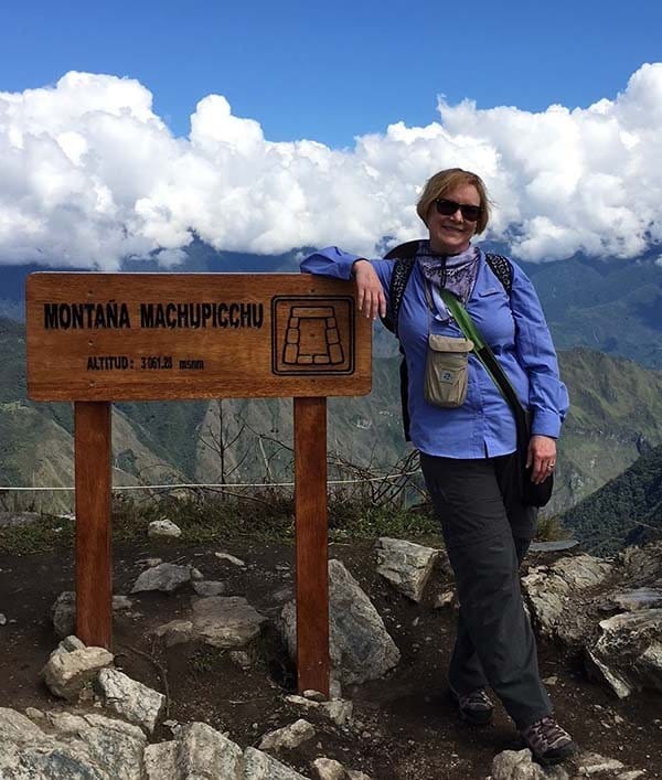 female client at the top of a mountain posing for the camera