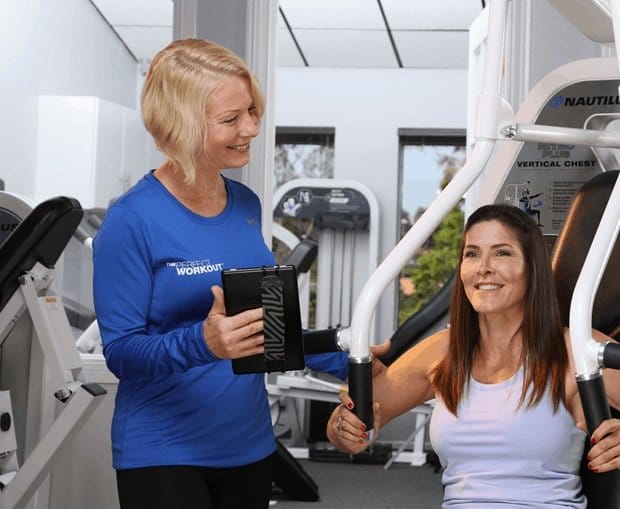 female client with a female personal trainer on a machine