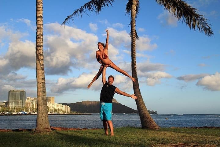 couple showing off their strength by doing cheerleading stunt