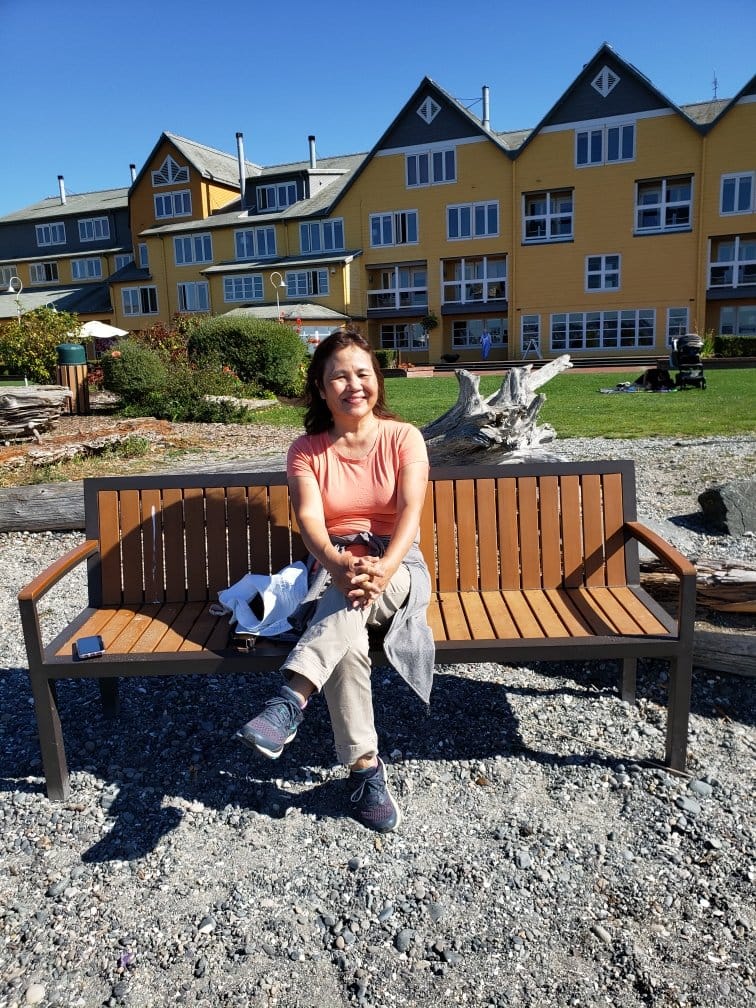 woman sitting on a park bench smiling