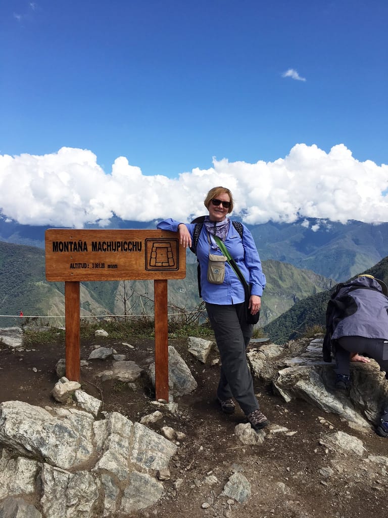 Female client standing on the top of a mountian
