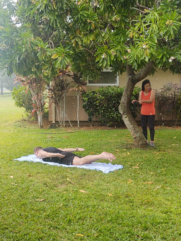 husband and wife doing virtual training workouts in the rain in Hawaii