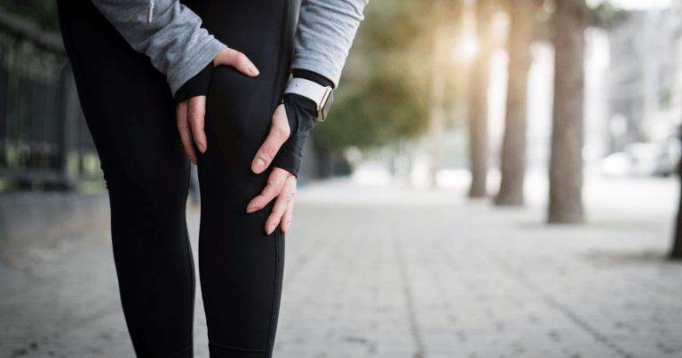 a person is holding their injured knee