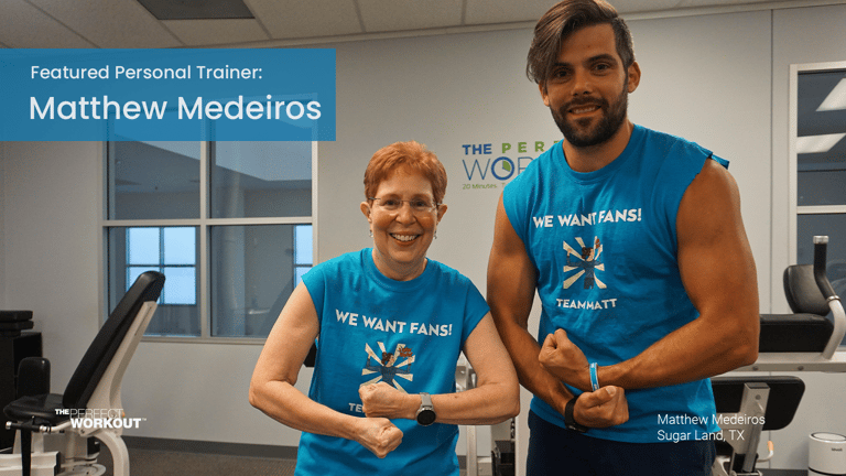 Trainer Matthew Medeiros flexing with a member in The Perfect Workout Sugar Land Studio