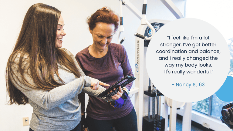 image of a trainer show a member their progress chart with a quote bubble next to them