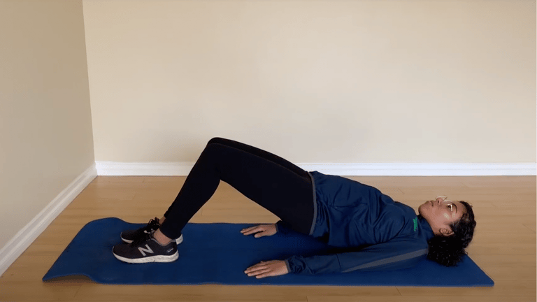 Trainer giving an example of a glute bridge workout