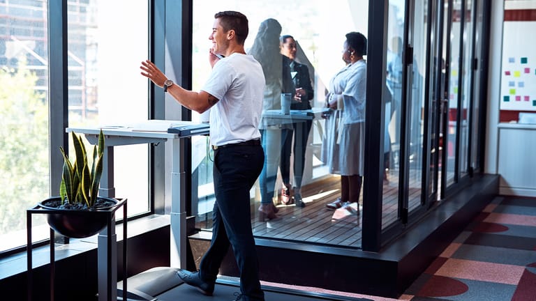 A man walking on a treadmill desk