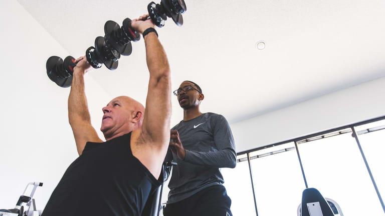A member of The Perfect Workout performs the Overhead Press exercise