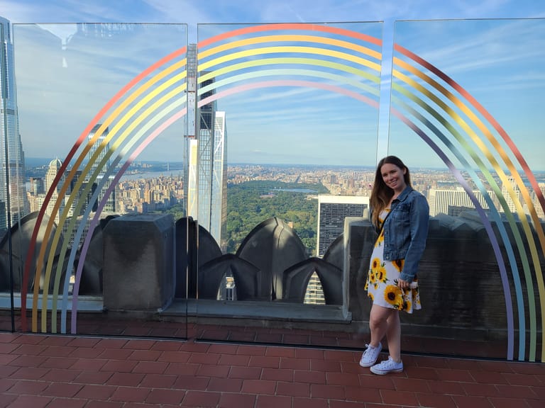 Raechel Larson standing by a rainbow