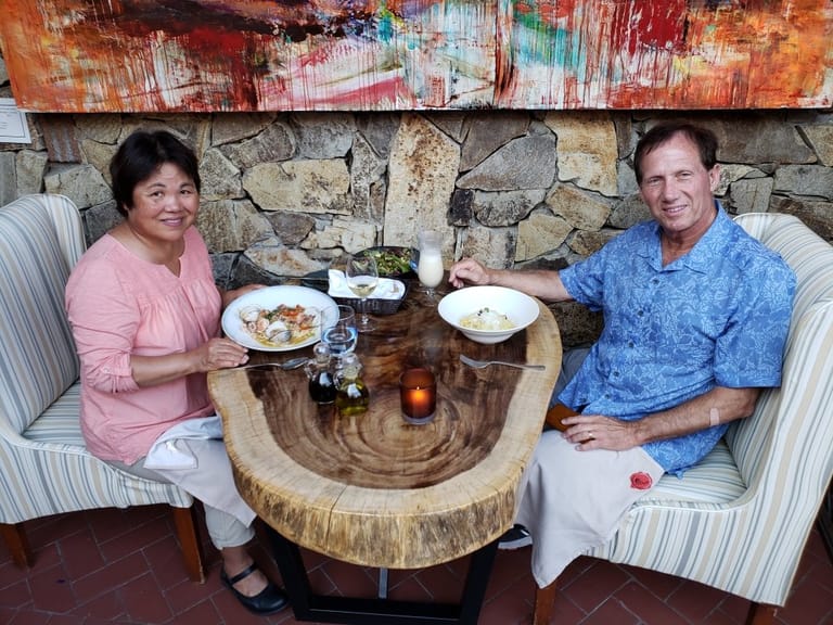 wife and husband smiling while eating dinner