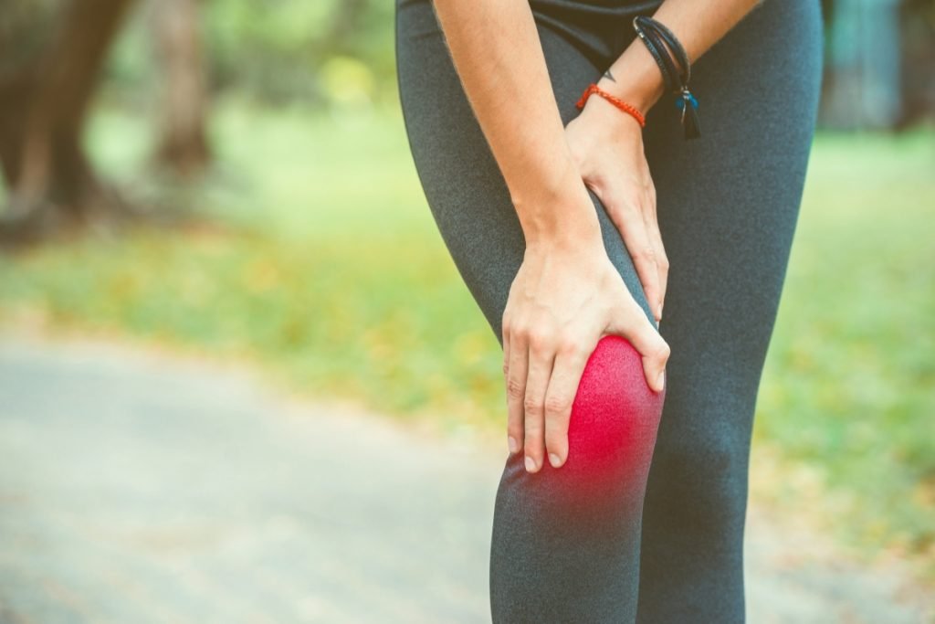 woman with her hand on her knee hurting from inflammation