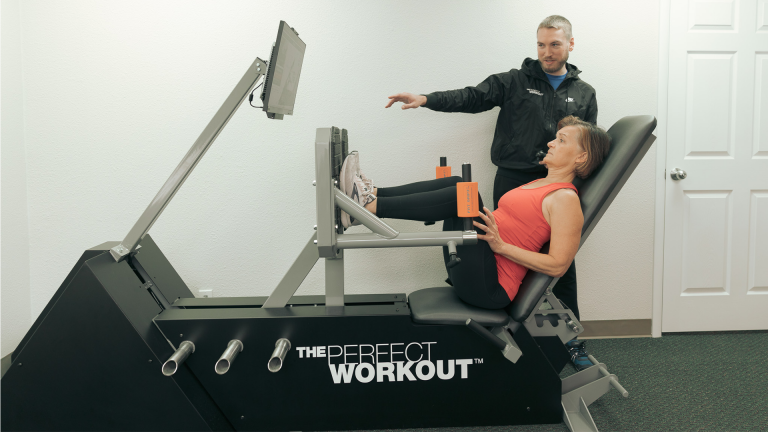 A female member of The Perfect Workout using a PRX machine
