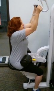 Female client strength training on a machine