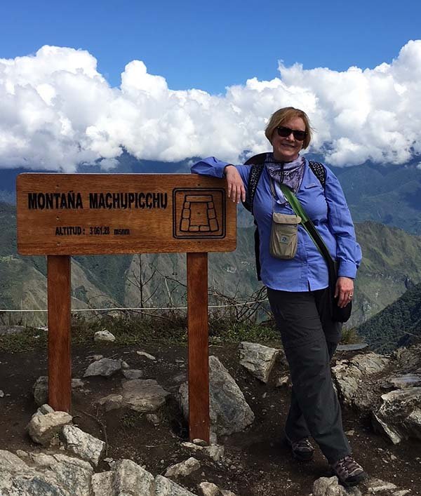 female client at the top of a mountain posing for the camera