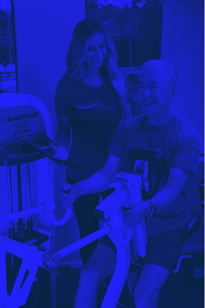 Man working out on machine with female trainer