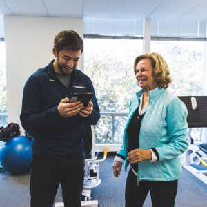 A trainer showing a woman the science behind slow motion strength training