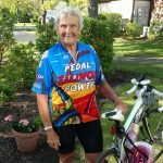 Elderly female client smiling next to her bike