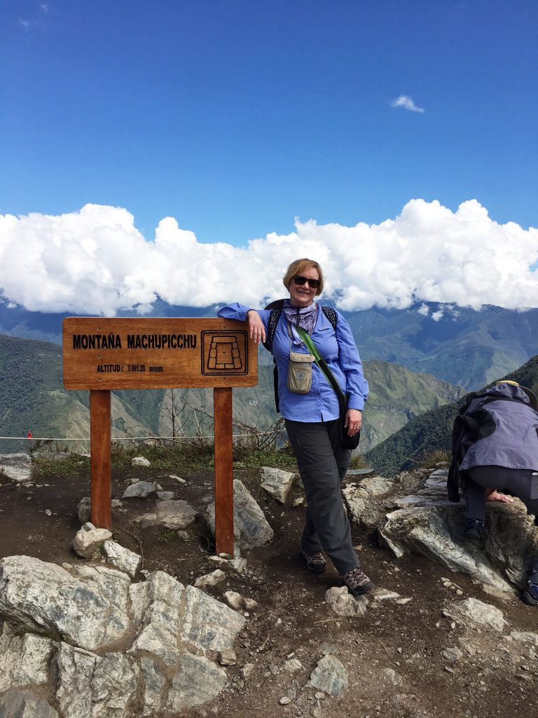 Female client standing on the top of a mountian
