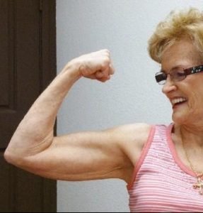 female client flexing her muscles as a result from strength training