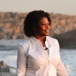 Female client smiling near the ocean