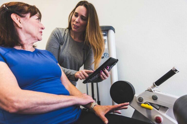 The Perfect Workout Member with Female Trainer working out on a weight machine