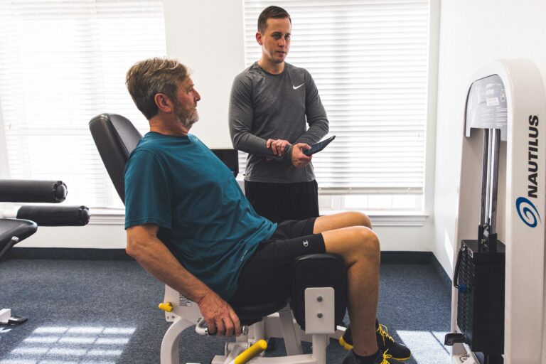 Personal Trainer with member on strength training machine
