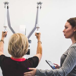 Trainer coaching woman on the Lat Pulldown machine