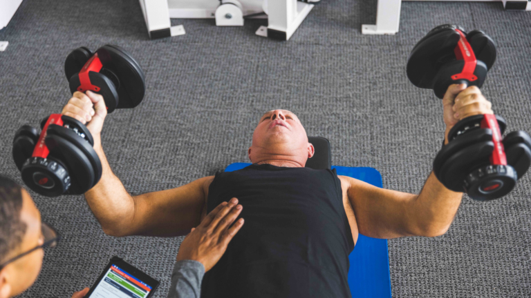 man training with two dumbbells