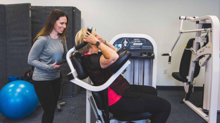 Female Trainer coaching a female on the Abdominal machine