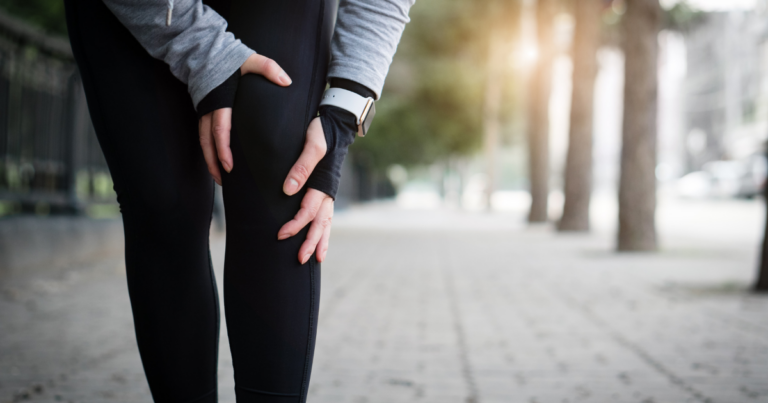 a person is holding their injured knee