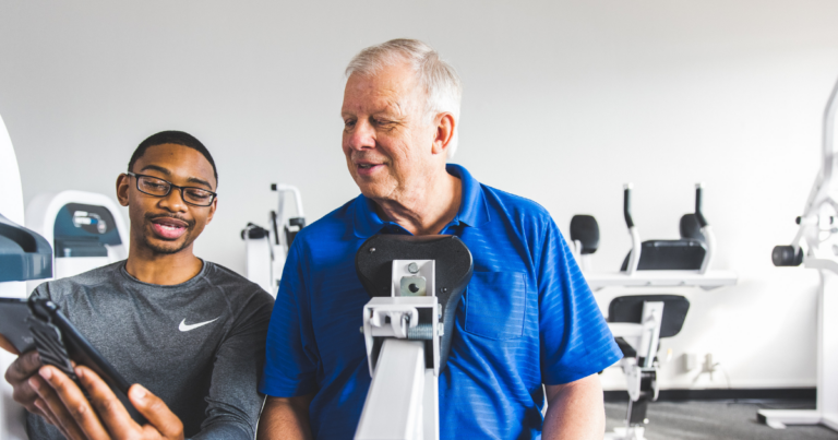 trainer showing a male client his progress on the compound row