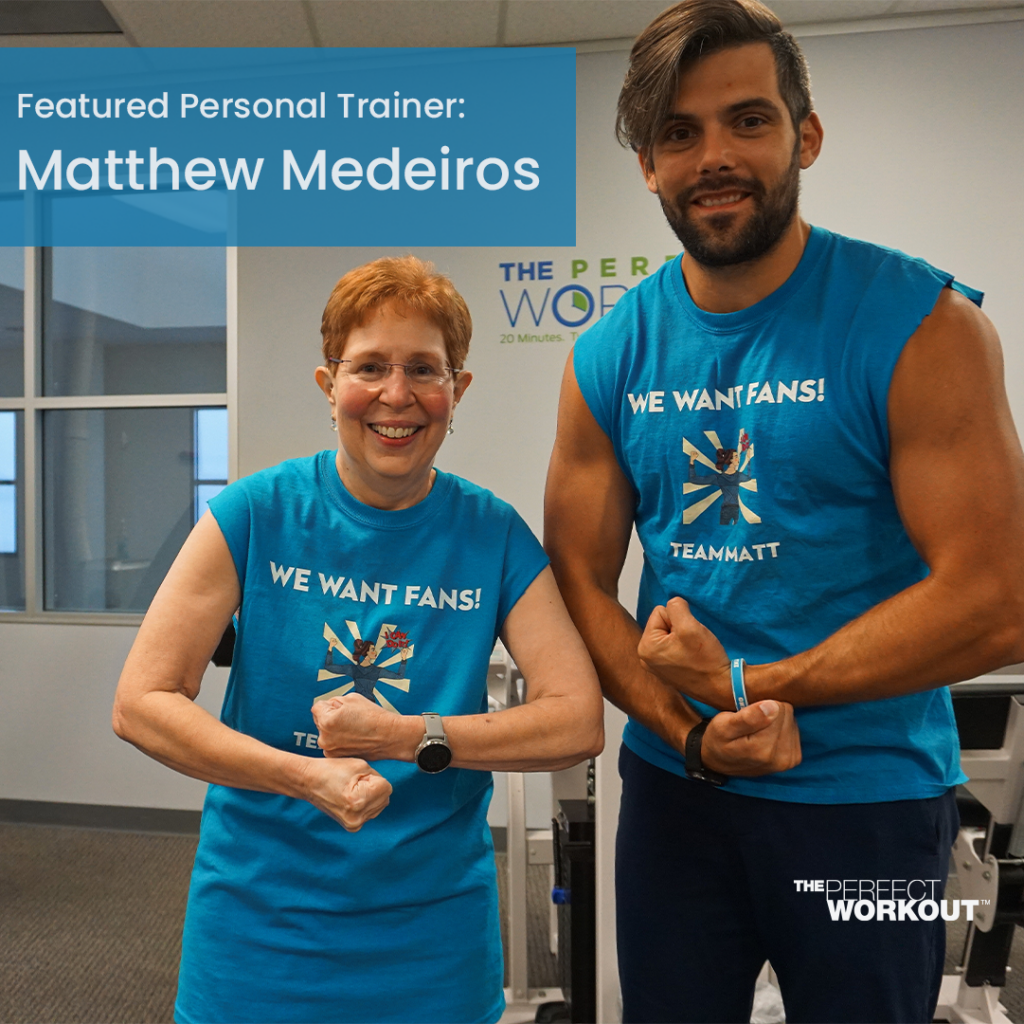 Trainer Matt Medeiros standing next to a TPW member while they flex their biceps