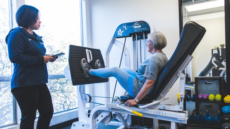 Image of member Carelle working out on the leg press machine