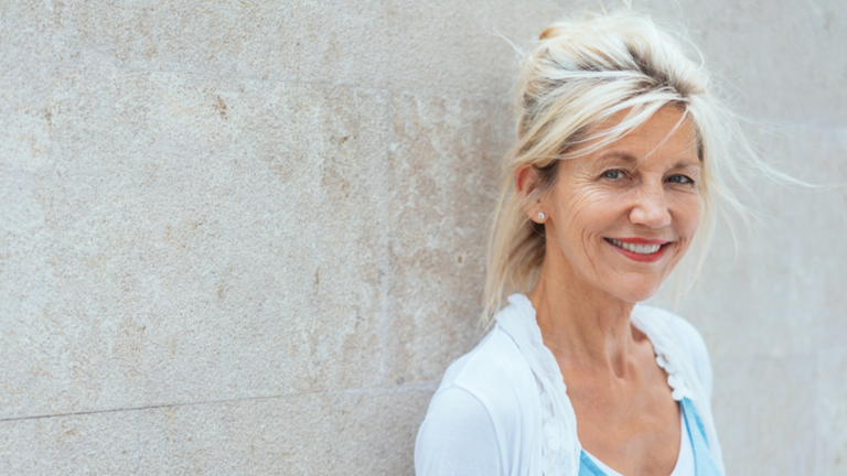 Image of a woman smiling while leaning against a wall