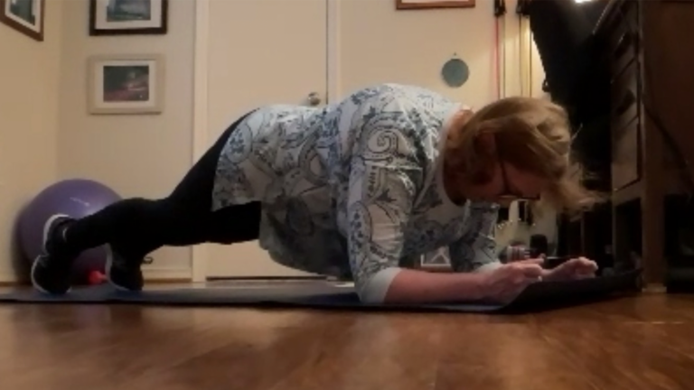 Image of Lois doing a plank exercise during her virtual training session with The Perfect Workout