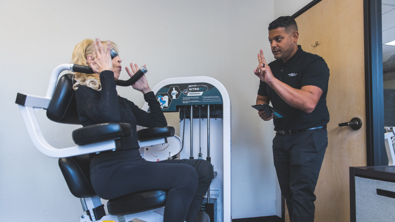 Image of a San Francisco Bay Area trainer helping a member of The Perfect Workout on the ab machine